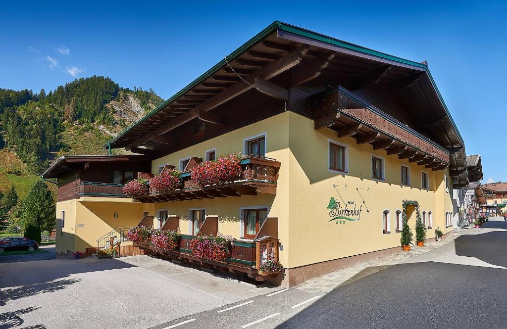 a building with flower boxes on the side of it at Frühstückshotel Birkenhof in Rauris