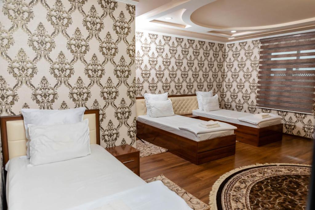 a bedroom with two beds and a couch at Rohat Hotel in Kokand