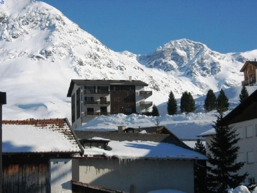 a snow covered mountain in front of a building at Curtinfess Rezzonico in Bivio