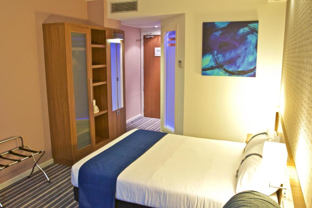 a bedroom with a bed and a painting on the wall at Holiday Inn Express Campo de Gibraltar-Barrios, an IHG Hotel in Los Barrios
