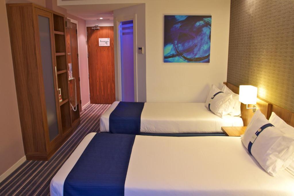 a hotel room with two beds in a room at Holiday Inn Express Campo de Gibraltar-Barrios, an IHG Hotel in Los Barrios
