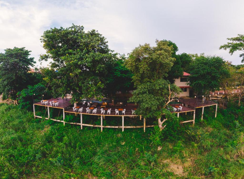 un groupe de personnes assises sur une terrasse dans un champ dans l'établissement Pilgrim's Kitchen & Inn, à Savannakhet