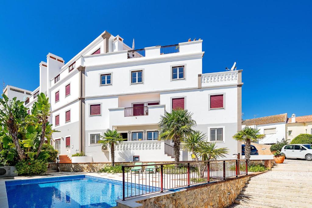 a white building with a swimming pool in front of it at Beco do Paiol 28 by Destination Algarve in Lagos