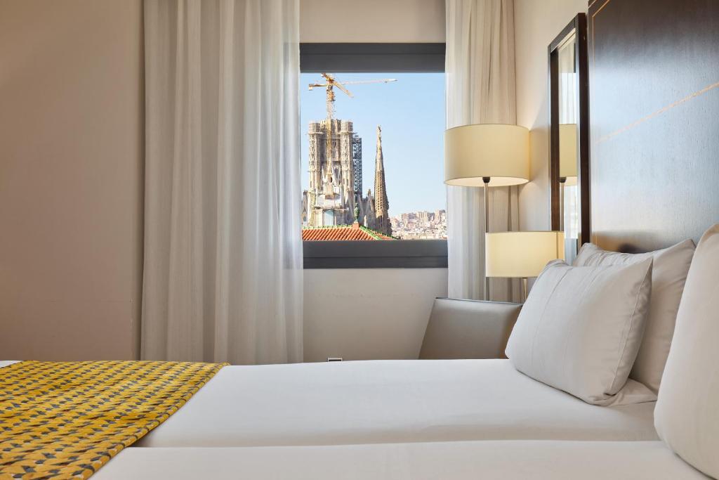 
a hotel room with a large bed and a large window at Eurostars Monumental in Barcelona
