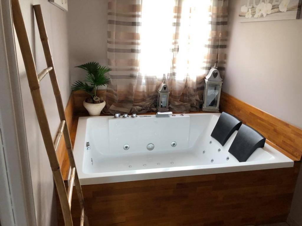 eine Badewanne in einem Zimmer mit 2 Stühlen in der Unterkunft La suite des charmelines in Fours-en-Vexin