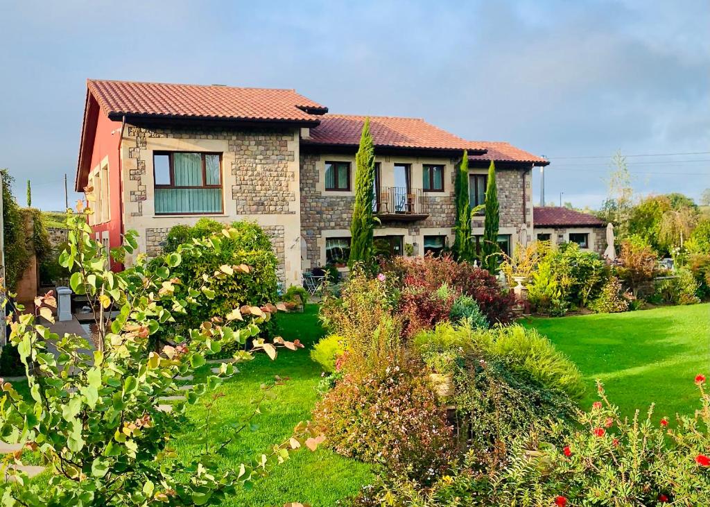 uma casa com um jardim em frente em La Fuentona de Santillana em Santillana del Mar