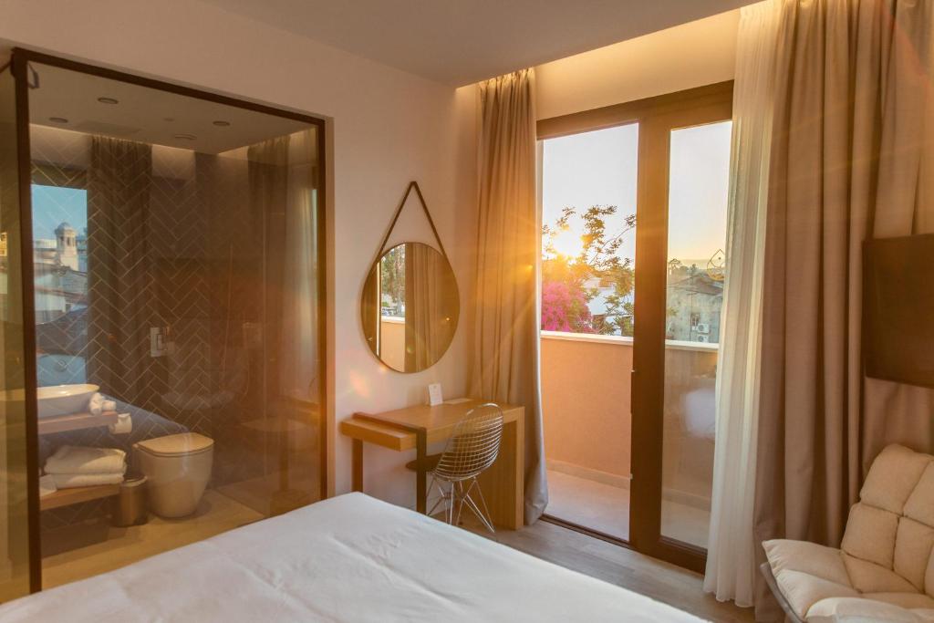 a bedroom with a bed and a balcony with a mirror at Old Port Hotel in Limassol