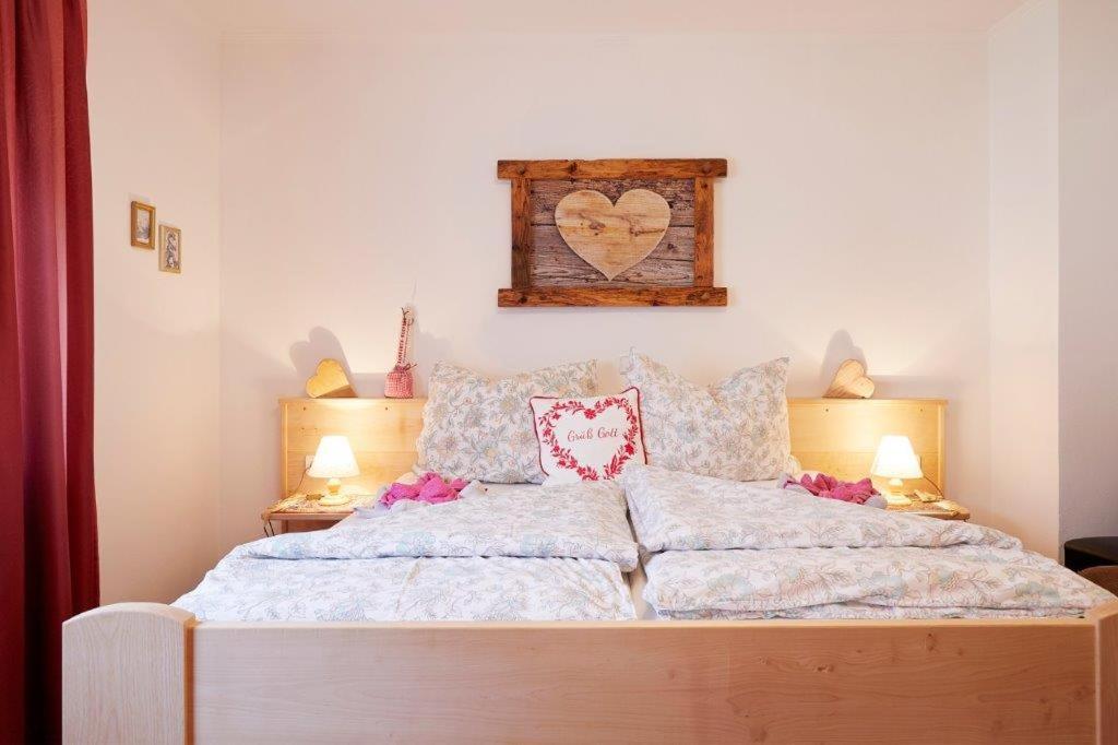 1 dormitorio con 1 cama grande y reloj en la pared en Bettys Ferienwohnung en Grafenweg
