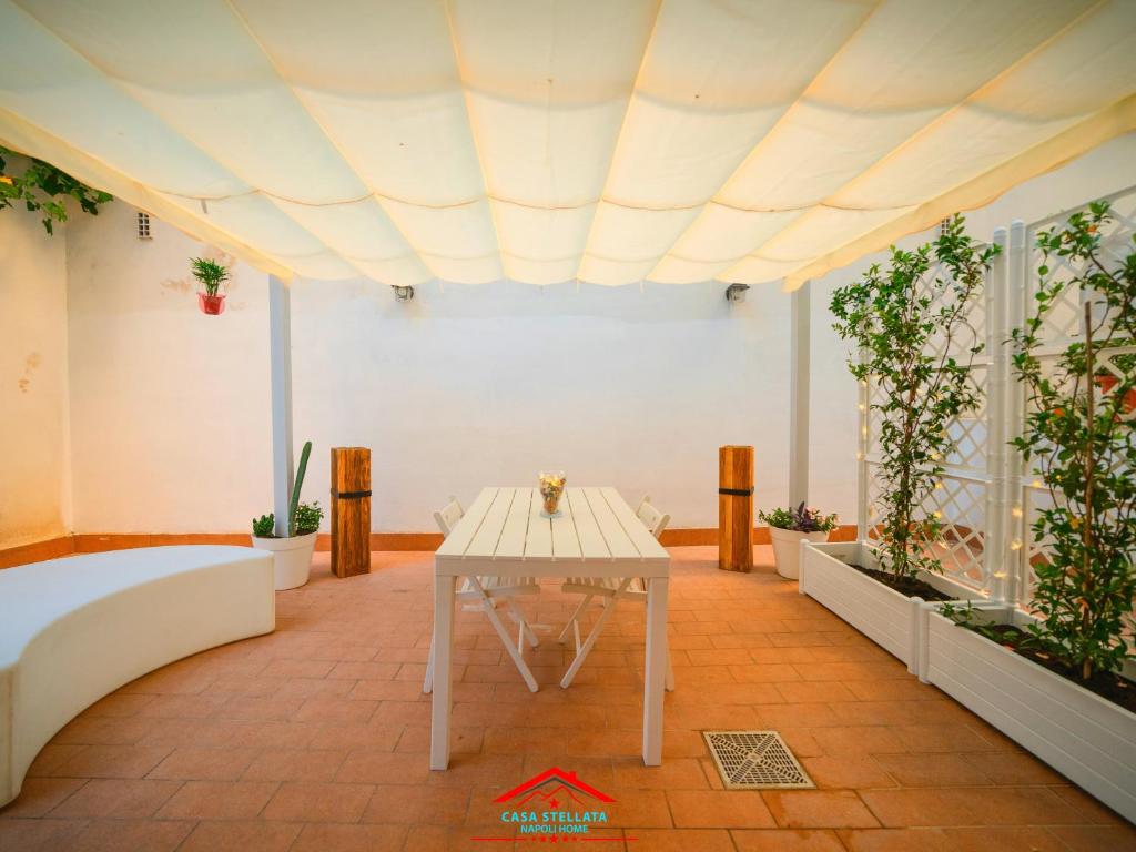 un tavolo bianco in una stanza con piante in vaso di Casa stellata Napoli home in the center a Napoli