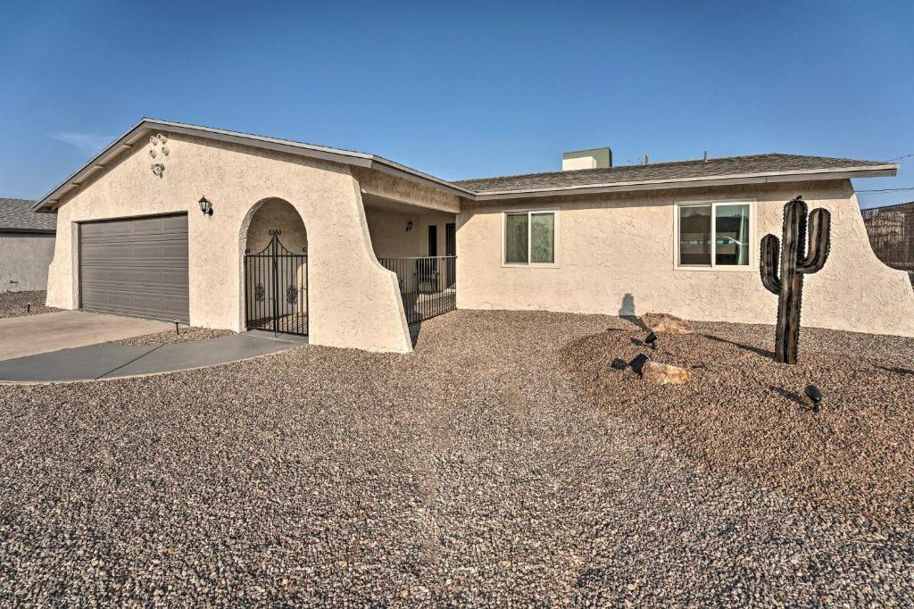 a house with a garage and a cactus at Havasu Getaway with Fire Pit and Grill Less Than 3 Mi to Lake in Lake Havasu City