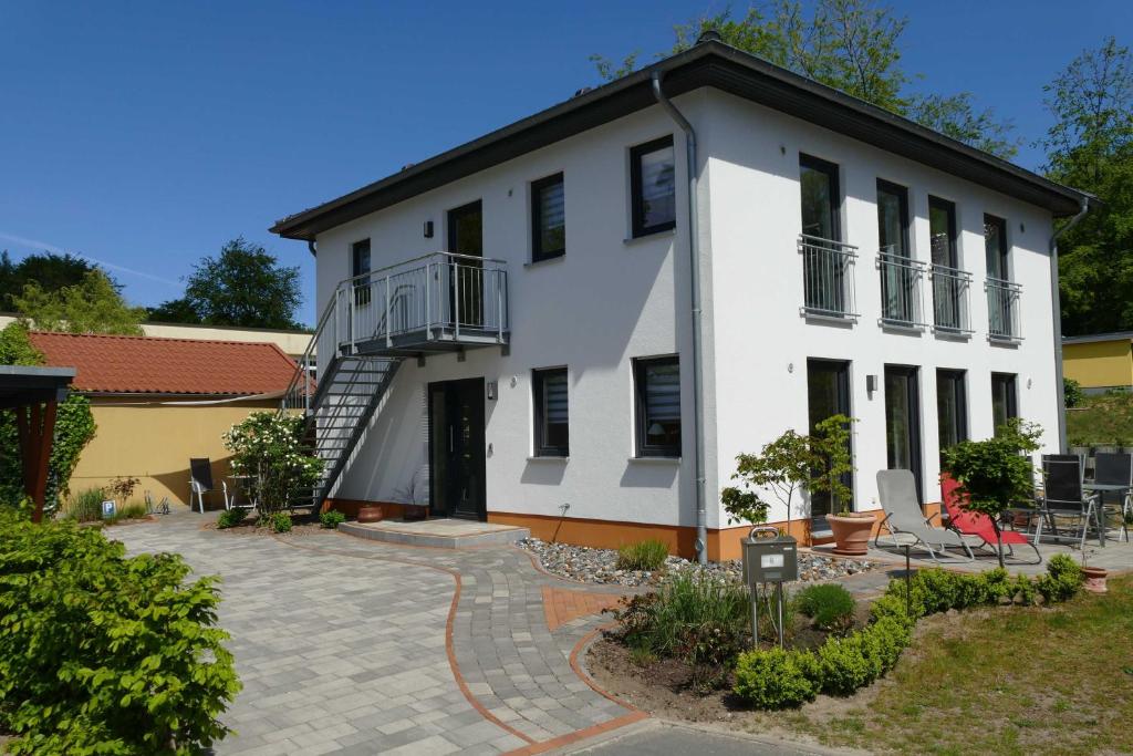 オストゼーバート・ゼリンにあるStadtvilla Sommerfrischeの大きな白い家で、正面にパティオがあります。