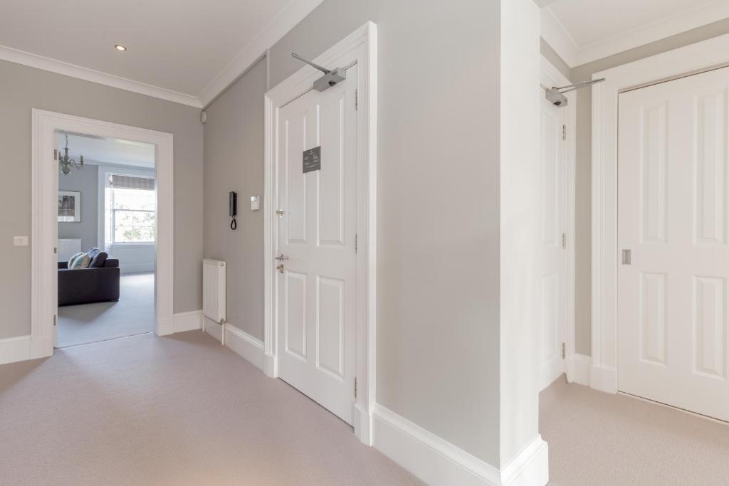 a hallway with white walls and white doors at Destiny Scotland - Q-Residence in Edinburgh