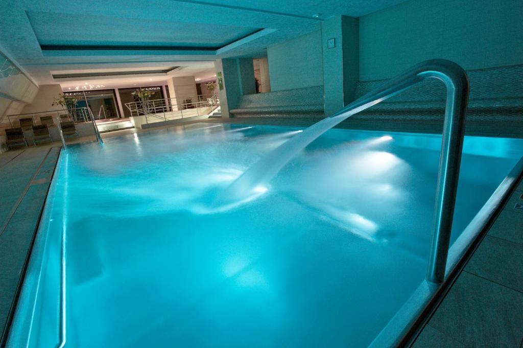 ein Pool in einem Hotel mit blauer Beleuchtung in der Unterkunft Harmony Club Hotel in Špindlerův Mlýn