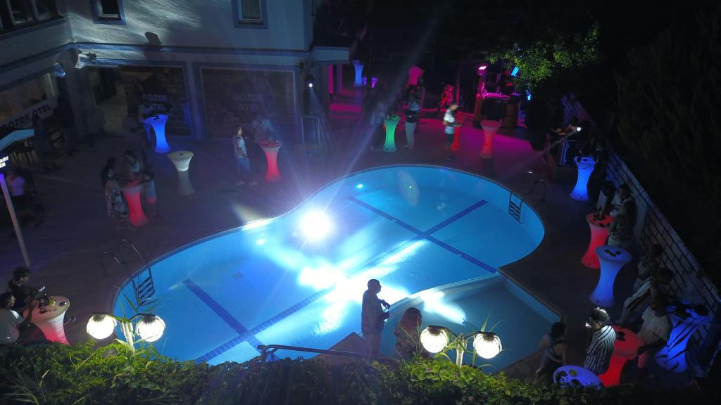 a man standing in front of a fountain at night at Gözde Butik Otel Belek in Belek