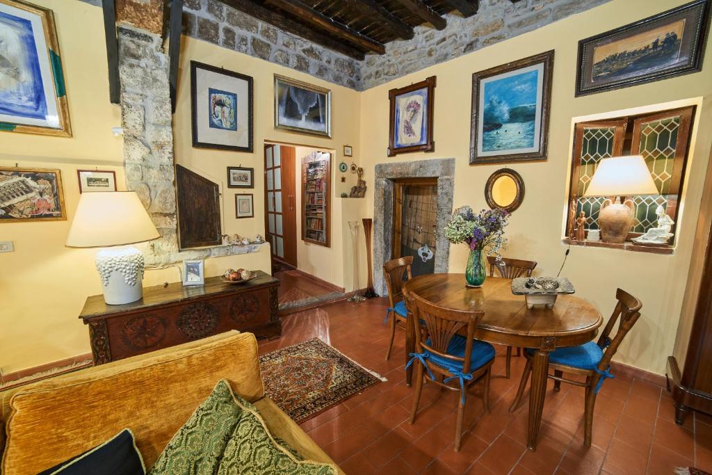 ein Wohnzimmer mit einem Holztisch und Stühlen in der Unterkunft Alloggio Turistico Centro Storico Malatesta in Montefiascone