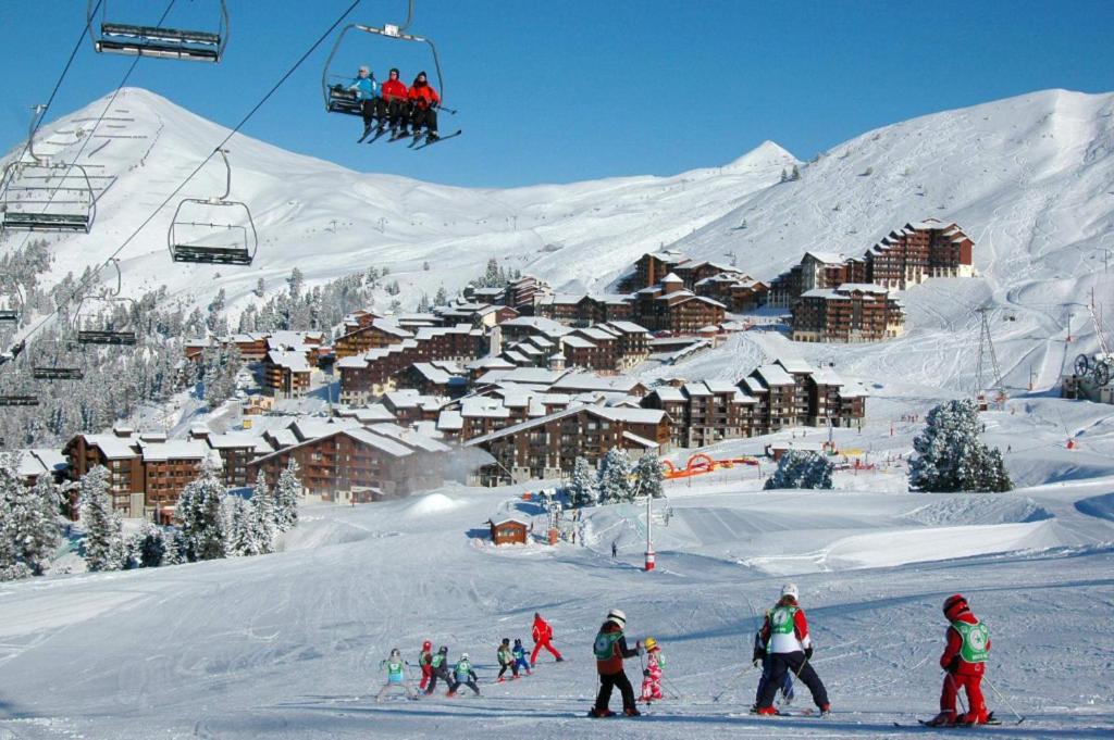 een groep mensen op een skilift in de sneeuw bij travelski home classic - Résidence Themis in La Plagne