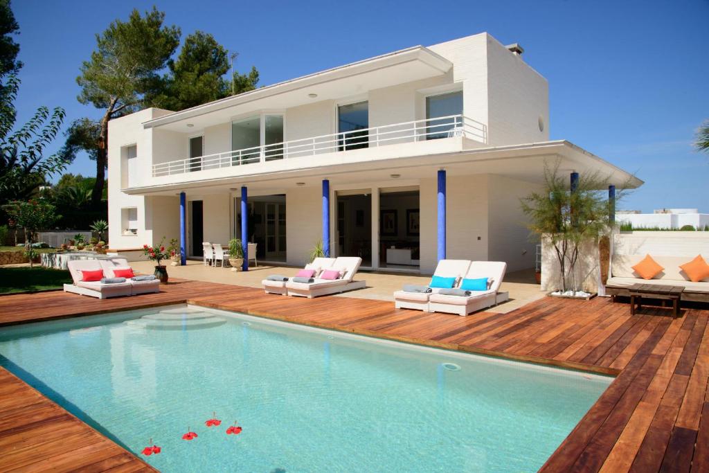 a villa with a swimming pool in front of a house at Villa Can Sala in San Antonio Bay