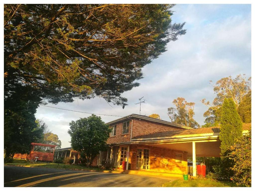 un vieux bâtiment en briques situé sur le côté d'une rue dans l'établissement Poplars Inn Mittagong, à Mittagong