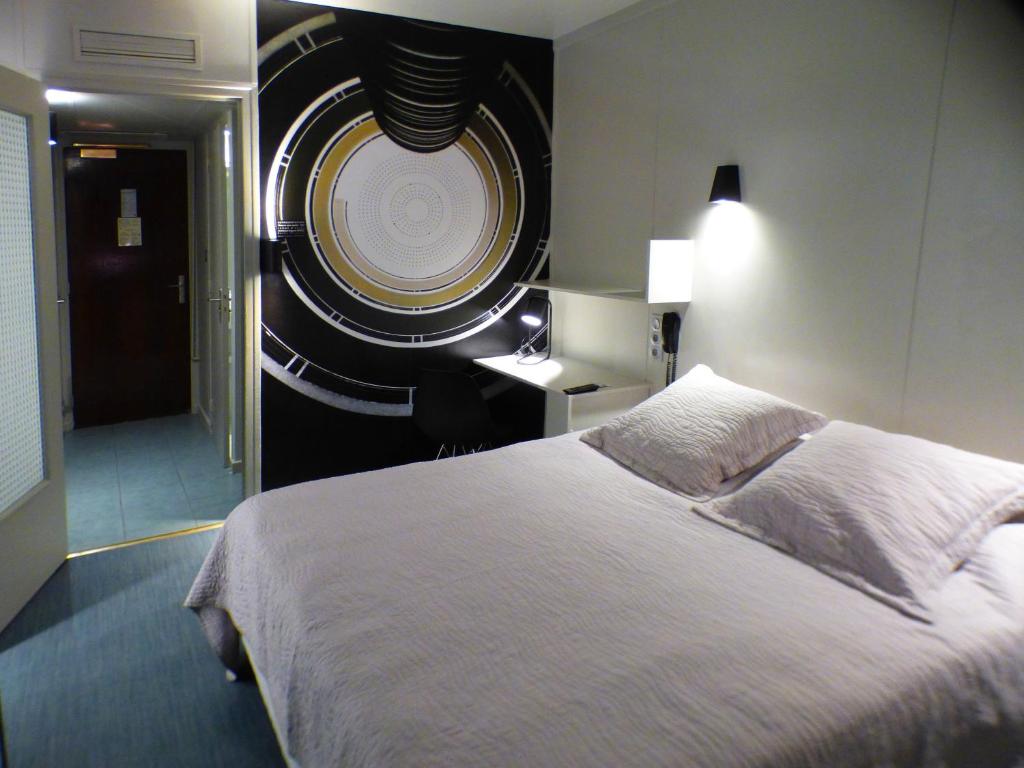 a bedroom with a large bed and a round window at Terminus du Forez Saint-Etienne Centre Gare Chateaucreux in Saint-Étienne