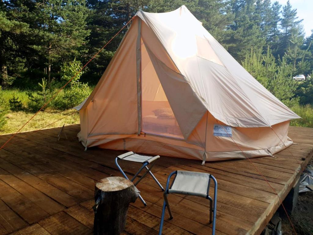 una tenda e una sedia su una terrazza in legno di Zarevo Glamping a Skobelevo
