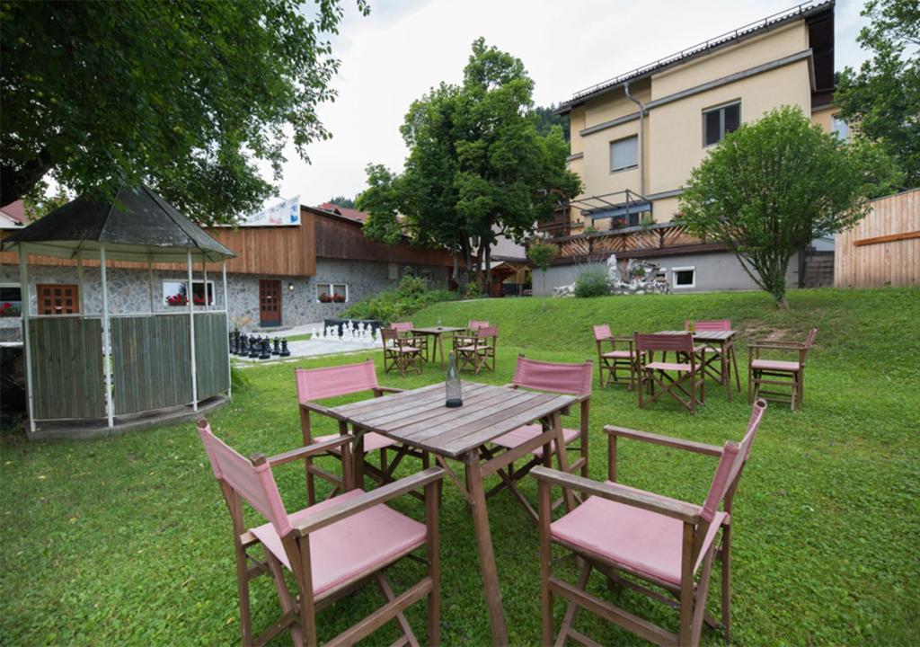 una mesa y sillas en un patio con cenador en Klub Zlata Ribica, en Jesenice