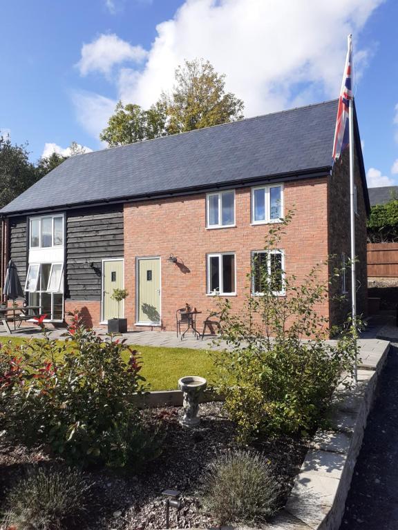 a brick house with a flag in front of it at 2 Bear Barns in Rhayader