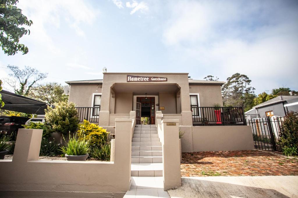 a house with a staircase in front of it at Flametree Guesthouse in Swellendam