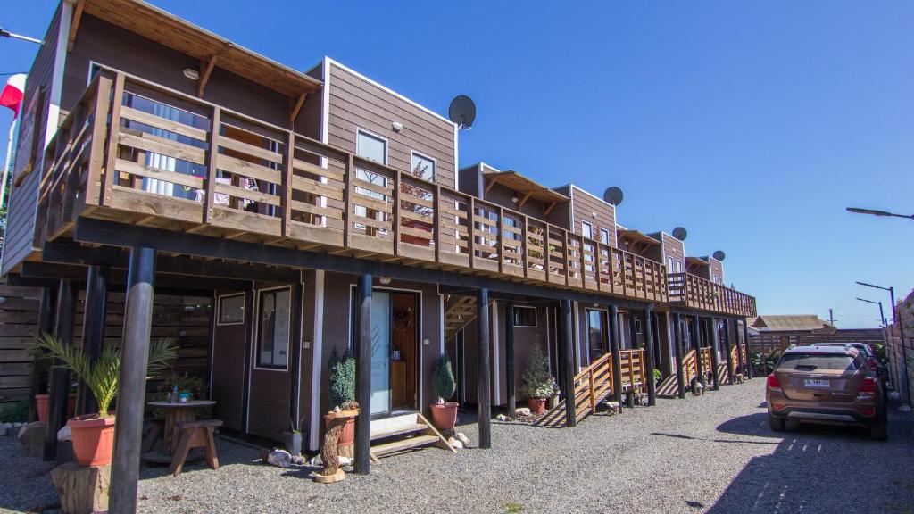 a building with wooden balconies on a street at ELUNEY Pichilemu in Pichilemu