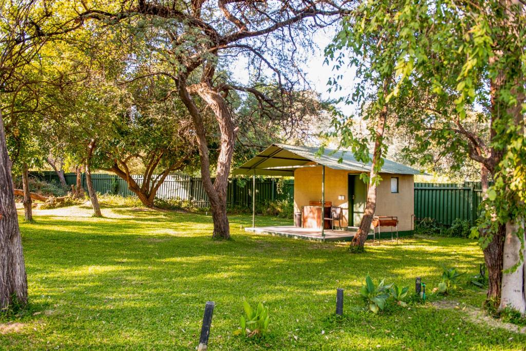 a house with a gazebo in a yard at Zambezi Mubala Campsite in Katima Mulilo