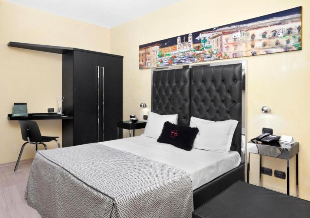 een slaapkamer met een groot bed met een zwart hoofdeinde bij LHP Suite Roma Piazza di Spagna in Rome