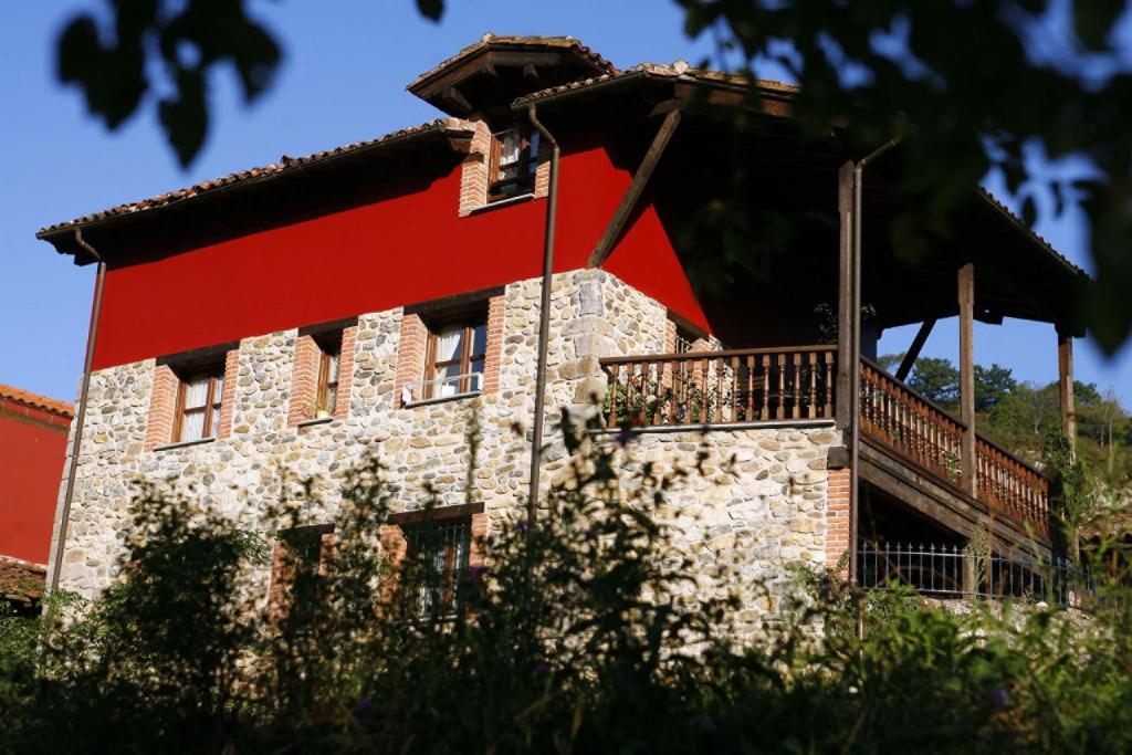 un edificio con techo rojo y balcón en Apartamentos San Francisco Rural, en Caño
