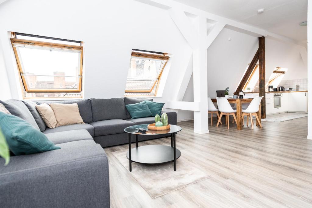 uma sala de estar com um sofá e uma mesa em Ko-Living - Händel Suite - Altstadt mit Küche, Smart TV & Dachterrasse em Halle an der Saale