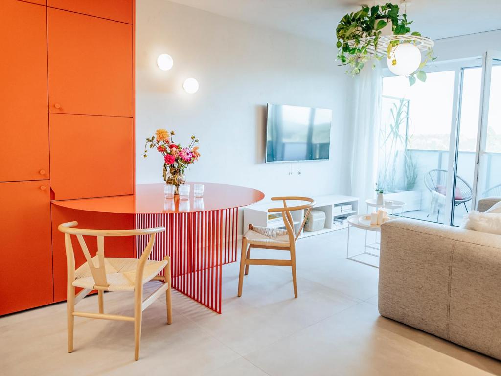 a living room with a red table and chairs at Concorde Silesian Place Apartments in Katowice