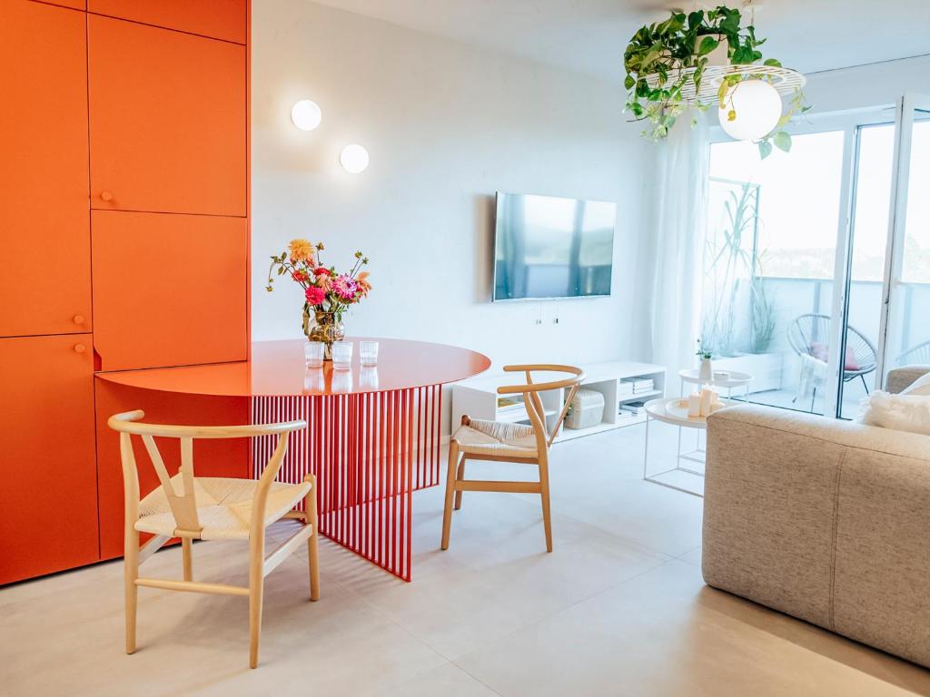 ein Wohnzimmer mit einem roten Tisch und Stühlen in der Unterkunft Concorde Silesian Place Apartments in Kattowitz