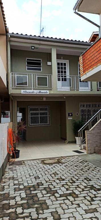 a house with a stone courtyard in front of it at Pousada Almeida in Florianópolis