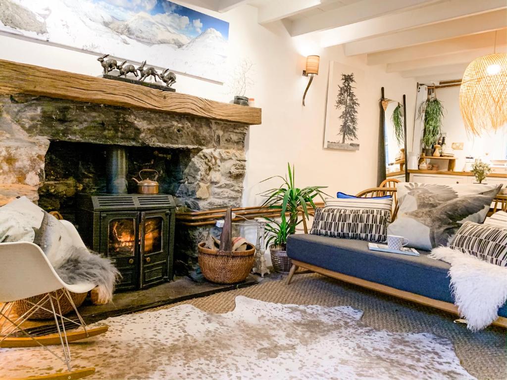 a living room with a couch and a fireplace at Snowdonia Stone Cottage in Beddgelert