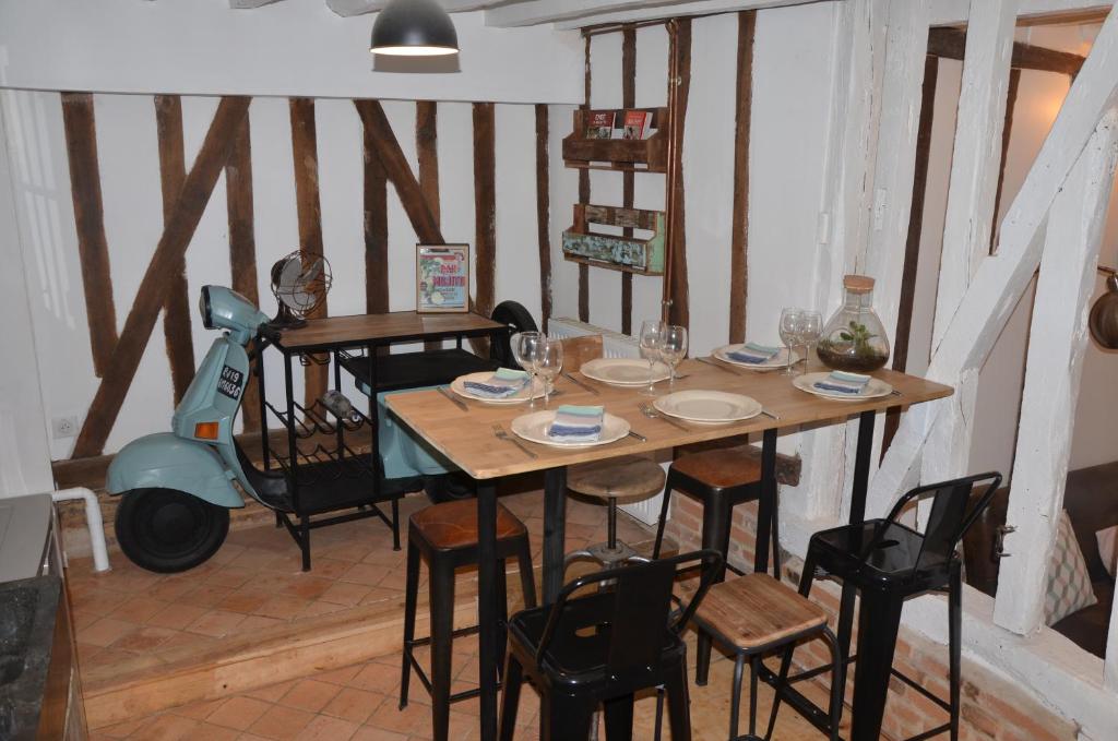 博韋的住宿－LA PETITE BEAUVAISIENNE，用餐室配有桌椅和摩托车