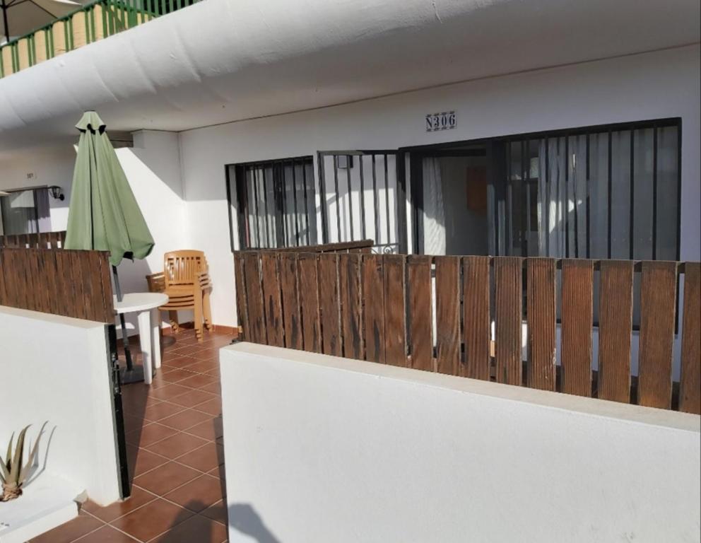 a room with a balcony with a table and a umbrella at Dunasol Fuerteventura in Corralejo