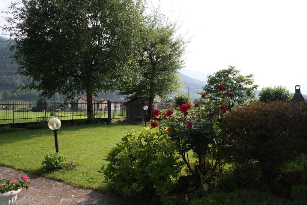 a garden with red roses and a fence at Casa vacanze in campagna in Clusone