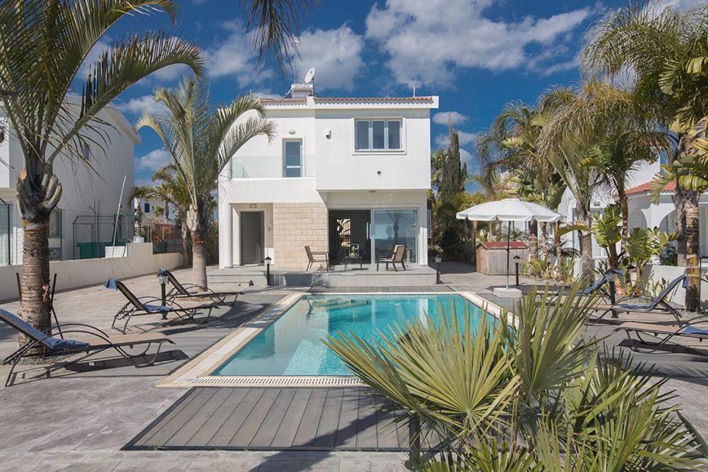 una casa con piscina frente a una casa en Villa Adaman - Stunning 3 Bedroom Seafront Villa with Pool - Close to the Beach, en Ayia Napa