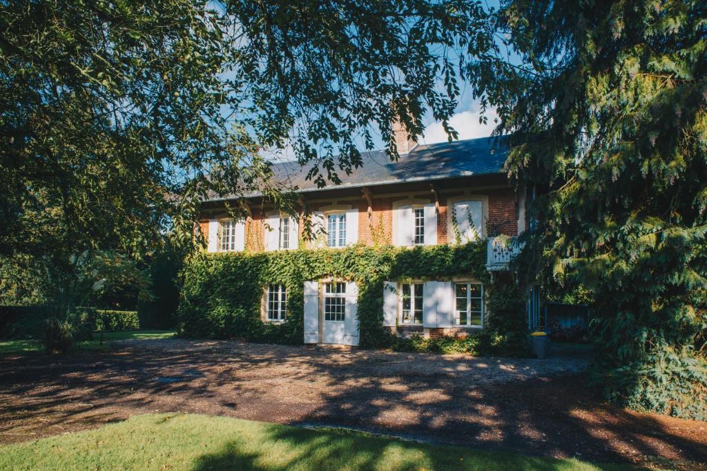 uma casa com hera a crescer ao lado dela em Château du Landin - Bains nordiques em Le Landin
