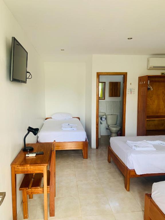 Postel nebo postele na pokoji v ubytování Hostal White House Galapagos