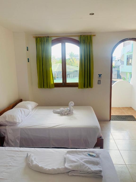 Postel nebo postele na pokoji v ubytování Hostal White House Galapagos