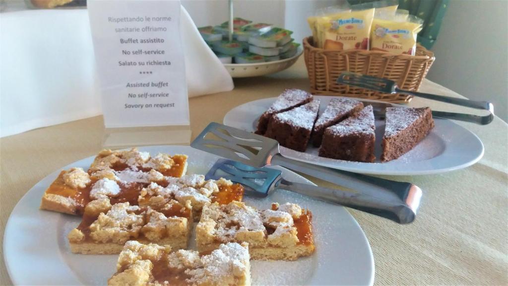 two plates of food on a table with desserts at Hotel Residence Villa Ascoli in Vieste
