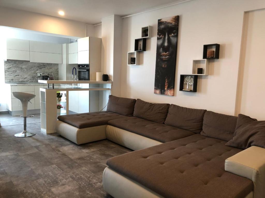 a living room with a brown couch and a kitchen at Luxury Westpark 2 Residence Lake View W6 in Bucharest