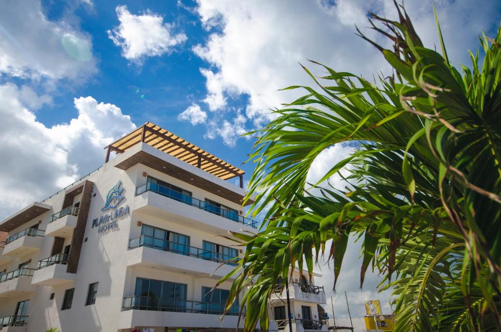 a building with a palm tree in front of it at Playa Linda Hotel in Progreso