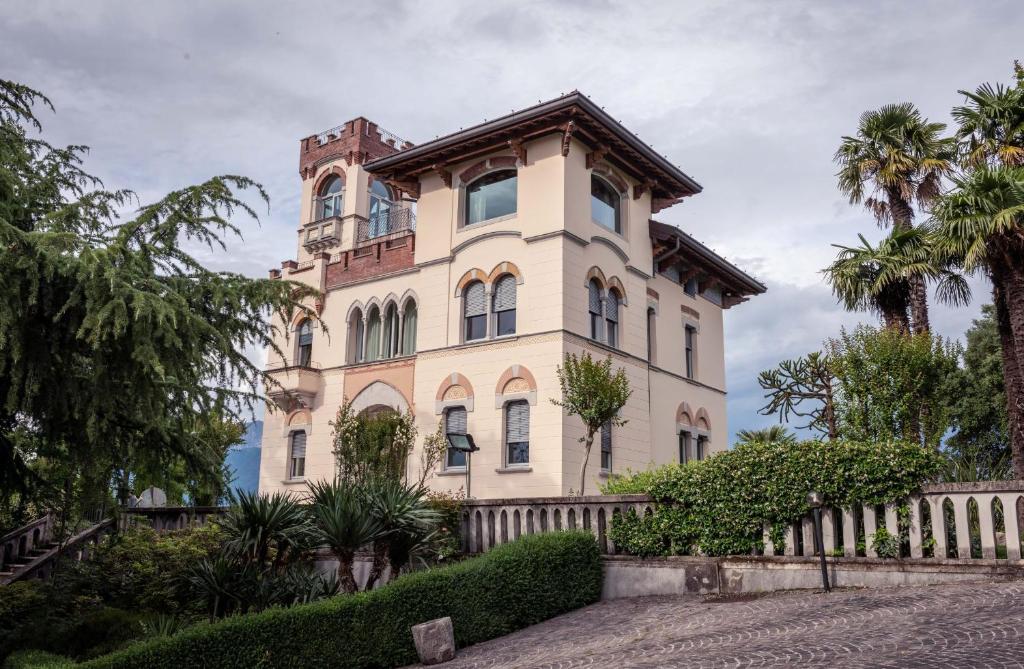 Villa della Giovanna by VacaVilla في Buia: مبنى كبير أمامه أشجار نخيل