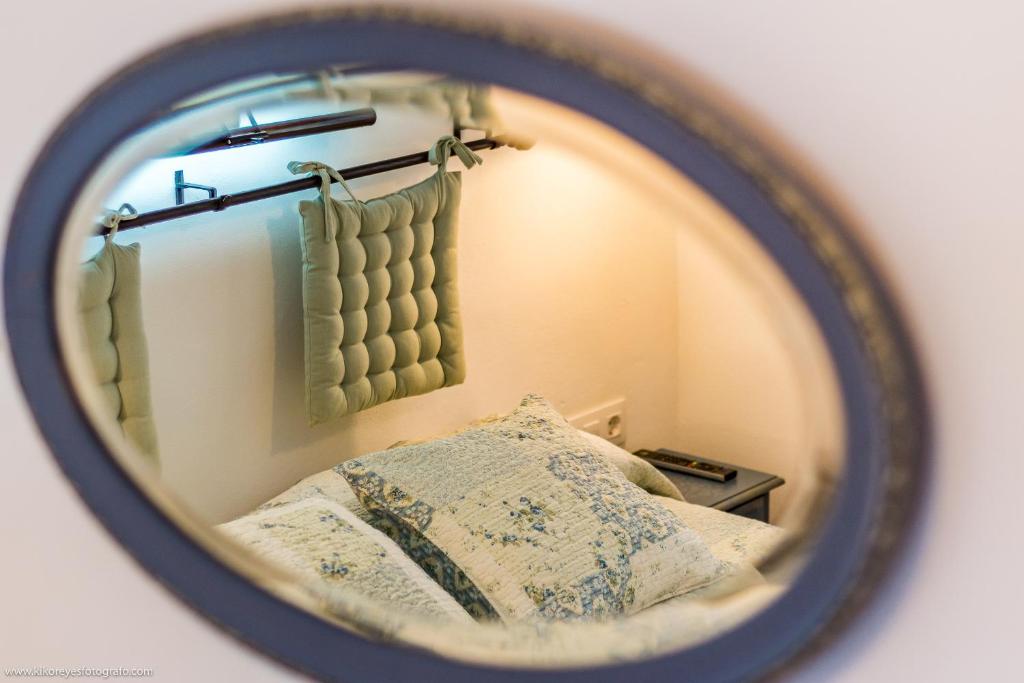 a mirror reflection of a bed in a bedroom at Cortijo El Indiviso in Vejer de la Frontera