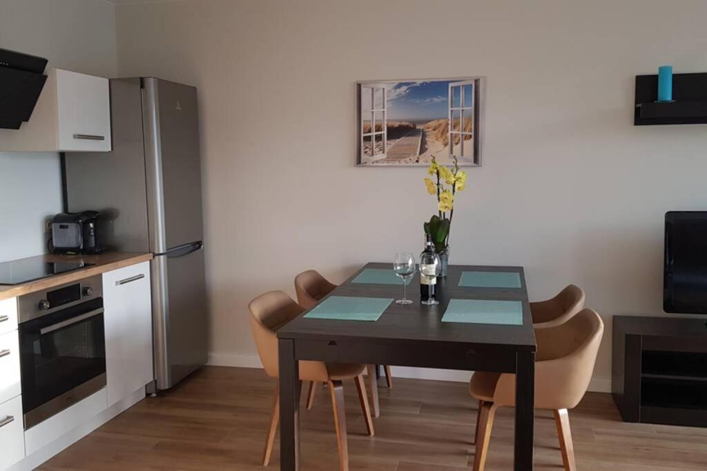 - une cuisine avec une table à manger et des chaises dans l'établissement Nowoczesny apartament przy Aquapark Reda, à Reda