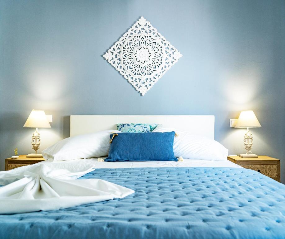 - une chambre bleue et blanche avec un grand lit dans l'établissement Ostraco Syros, à Vári